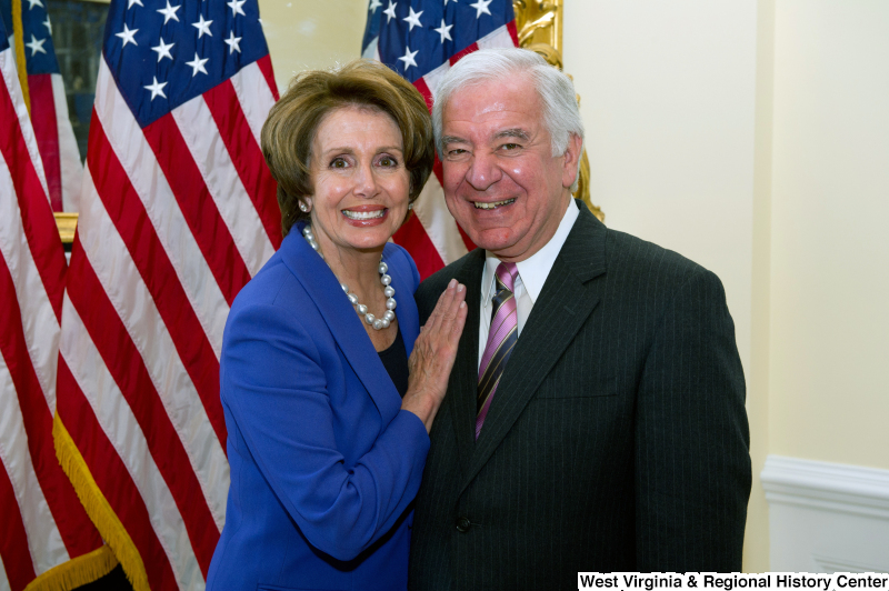 Congressman Rahall and Nancy Pelosi stand in front of United States flags.